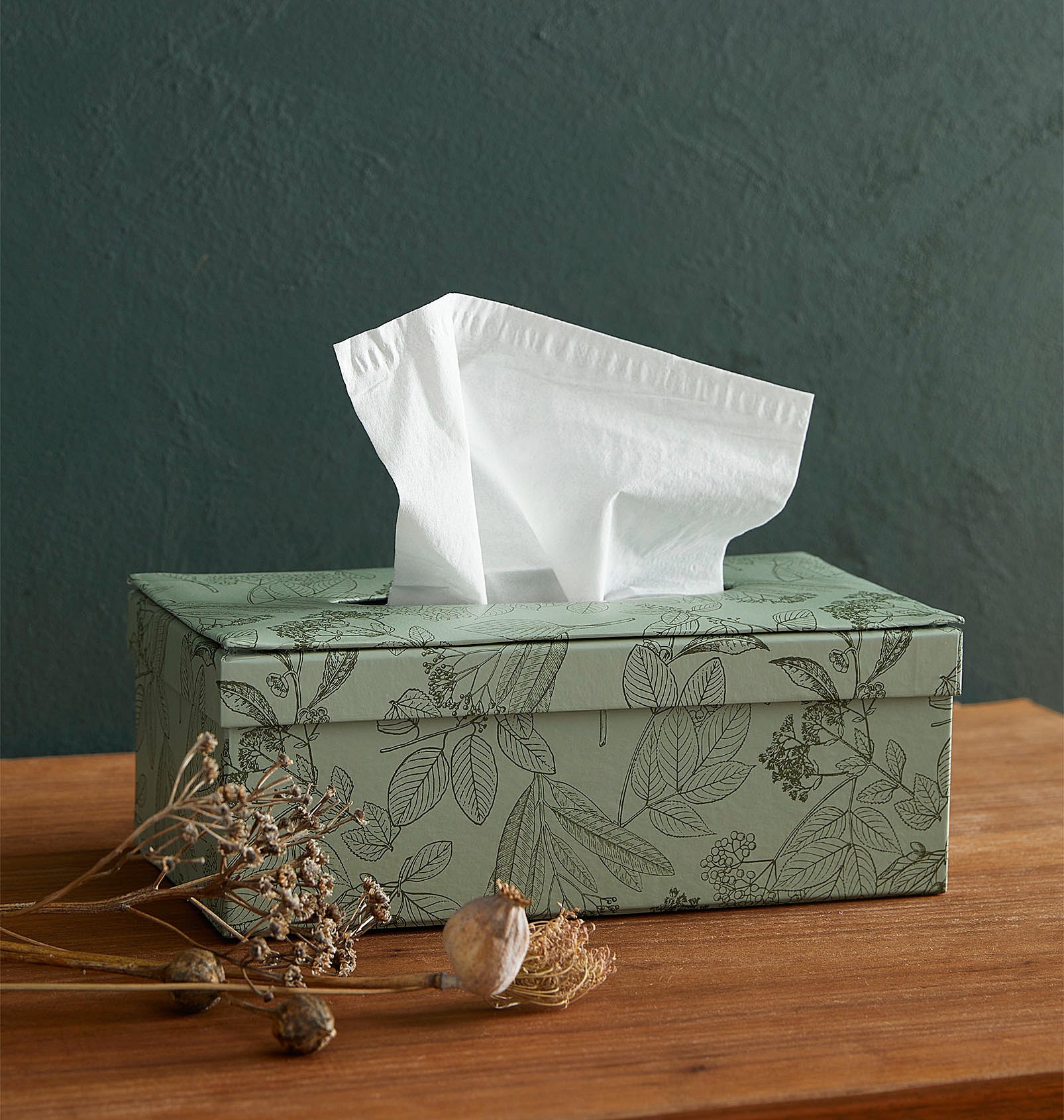 A tissue box holder with a tissue sticking out of it 