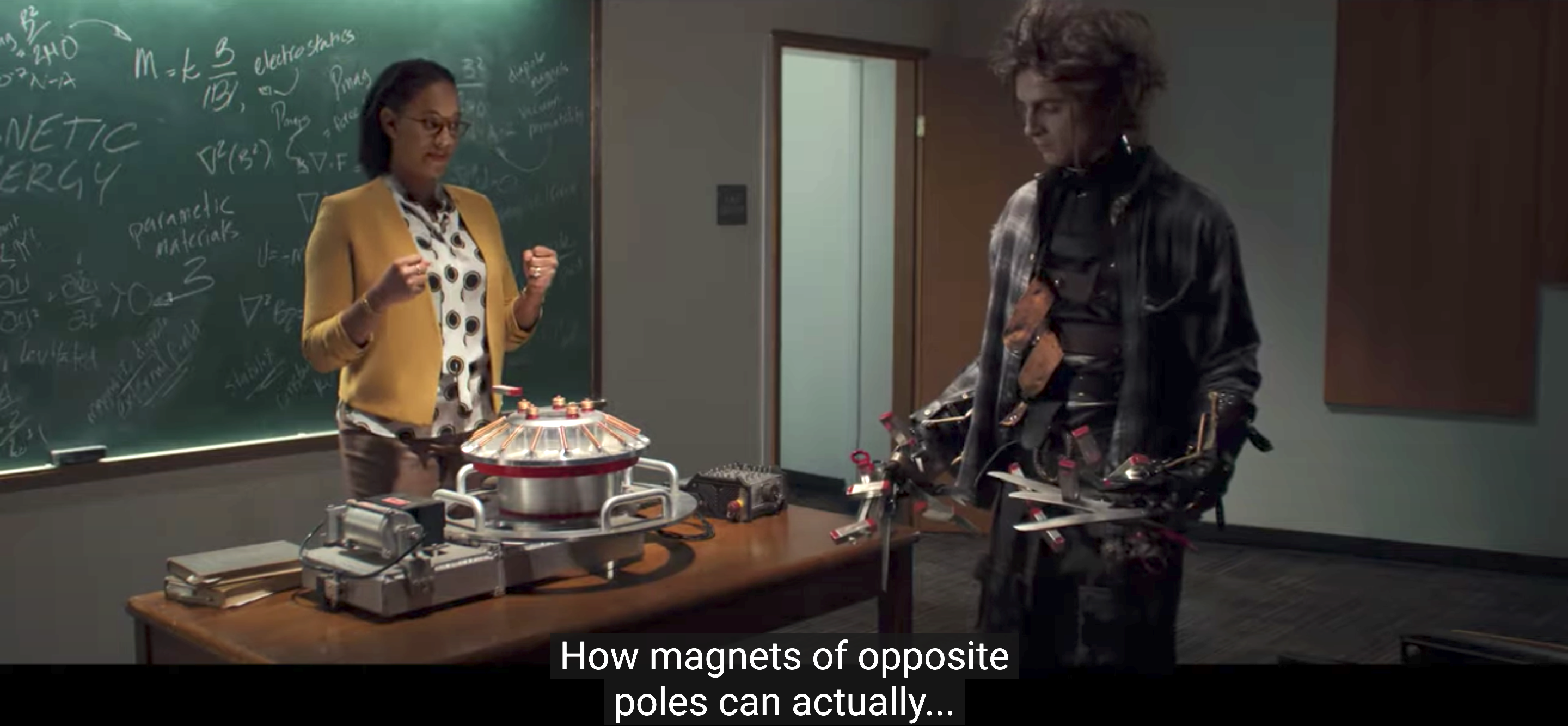 Edgar standing in a classroom with magnets attached to his scissorhands