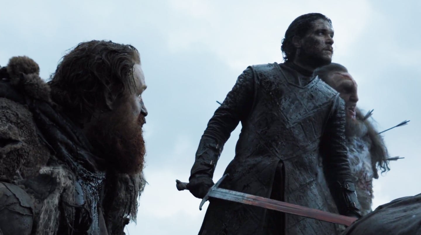 tormund looks up at jon snow who is holding a sword