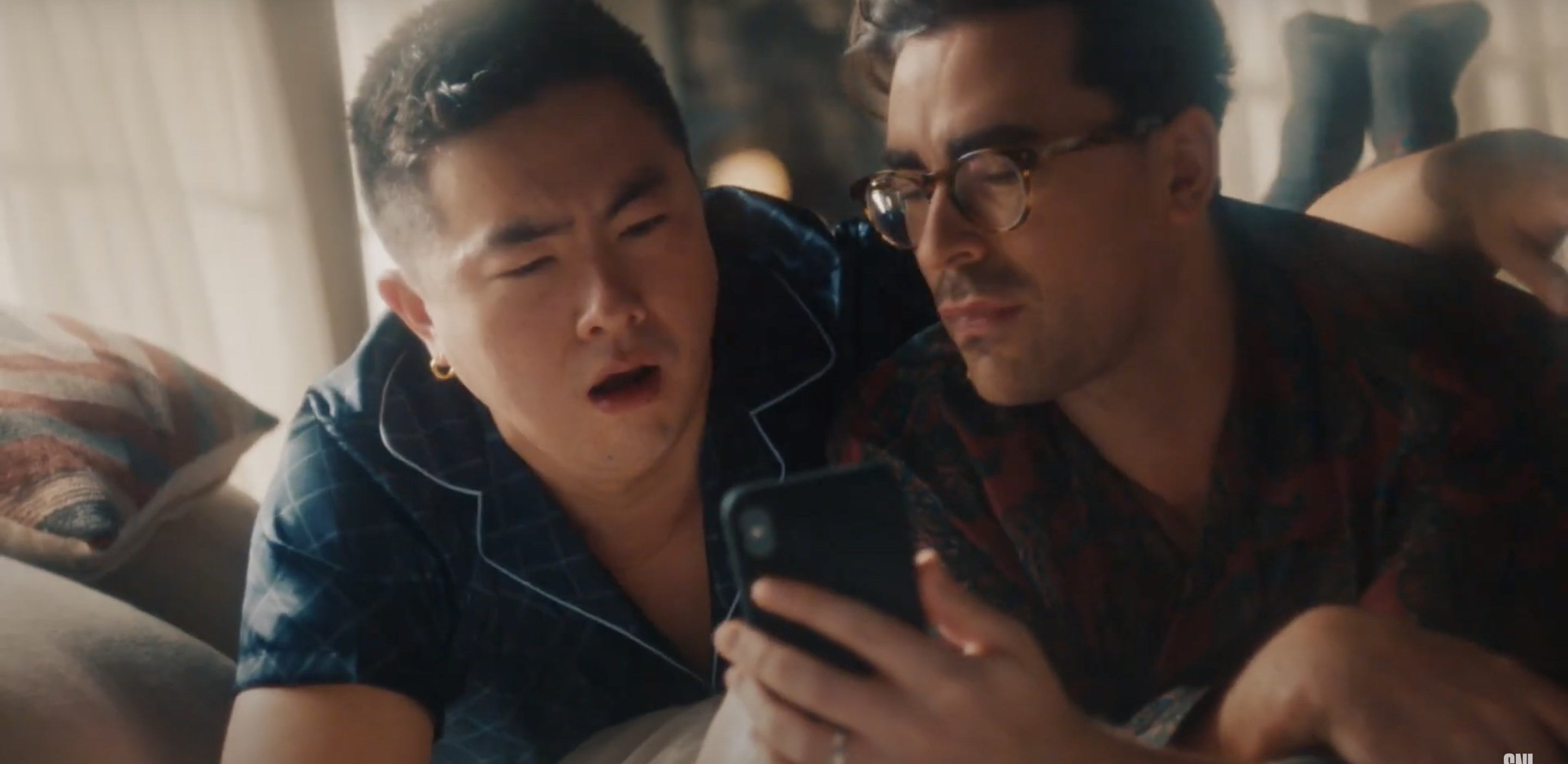 Two men look excited while browsing Zillow on their phone