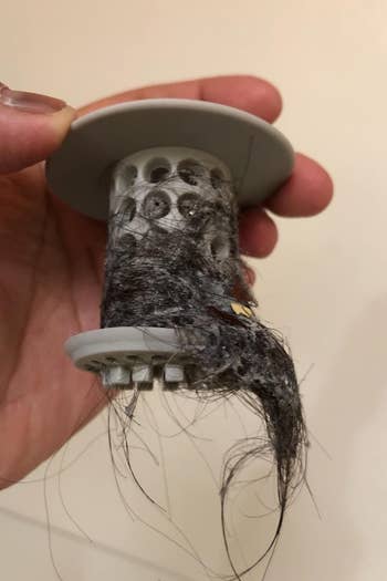 a reviewer photo of the tubshroom with a lot of hair in it