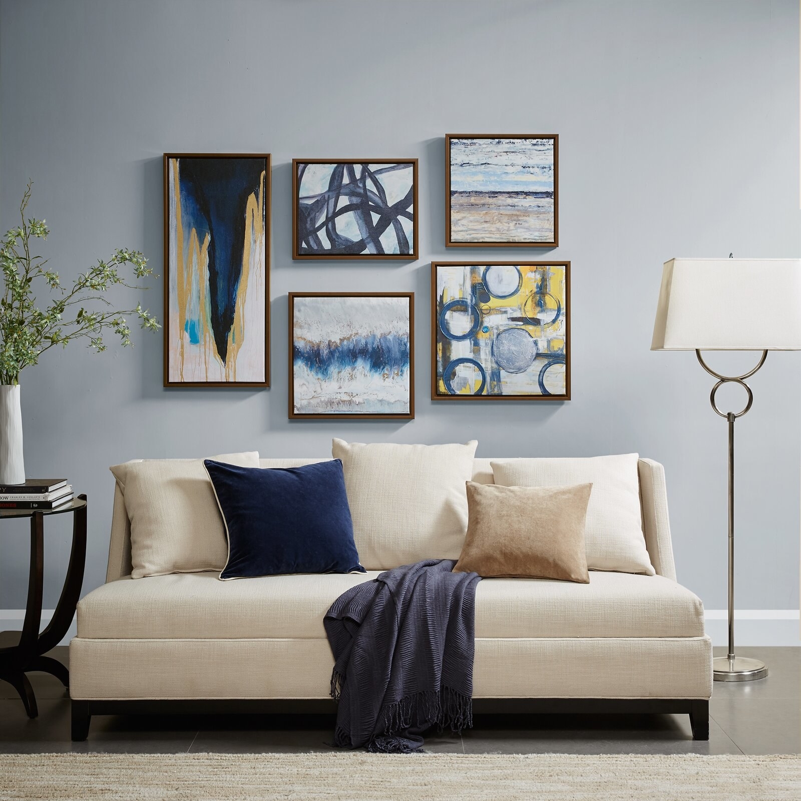 five pieces of blue wall decor hanging over a couch