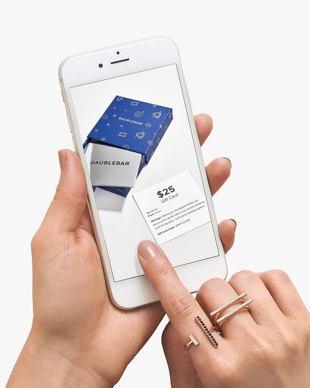A hand using their smartphone to open a BaubleBar e-gift card