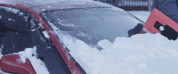 GIF of someone using the snow broom to clear snow off their car