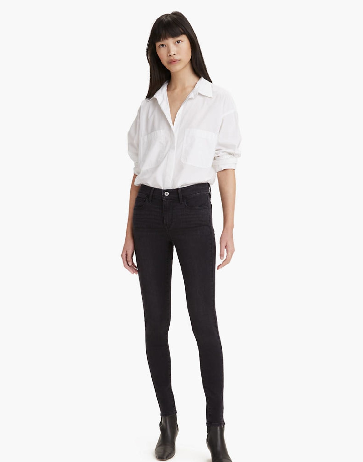 Model is wearing a white top and black denim skinny jeans