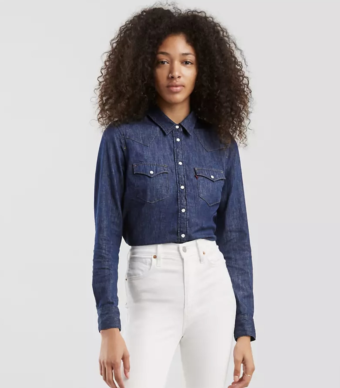 Model is wearing white jeans and a dark blue denim shirt