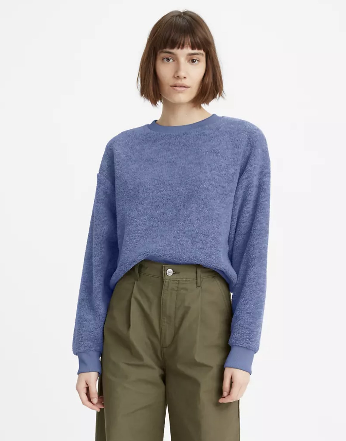 Model is wearing olive pants and a blue crewneck sweatshirt