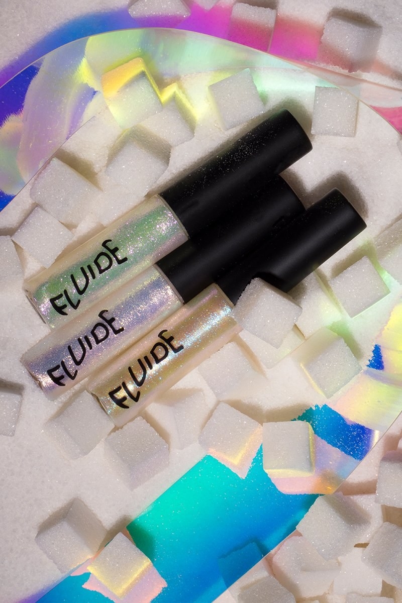 Glittery holographic lip glosses next to sugar cubes