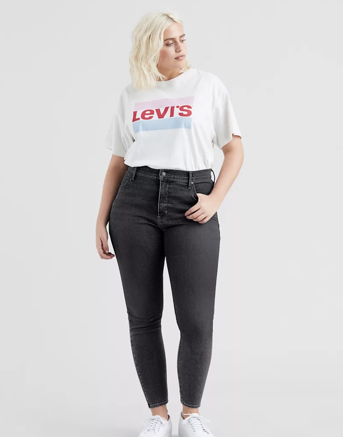 Model is wearing black skinny jeans and a white graphic tee