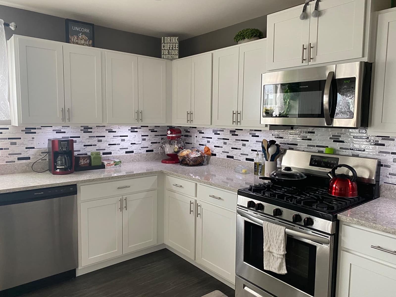reviewer image of the white marble peel and stick tile used as backsplash in a customer&#x27;s kitchen