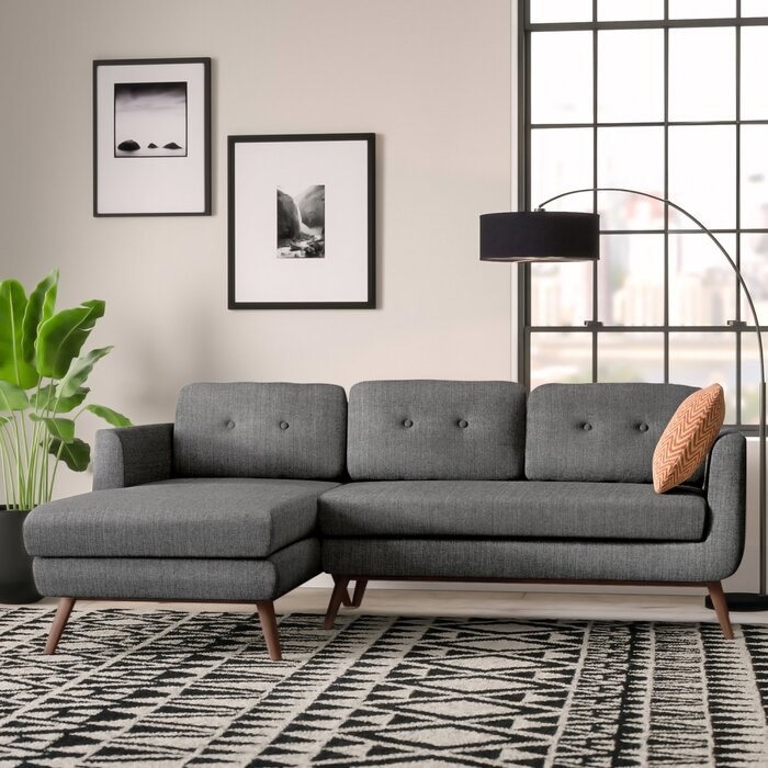 gray living room sectional couch with pillows on it