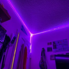 The lights installed around the edges of a ceiling with the color set to purple