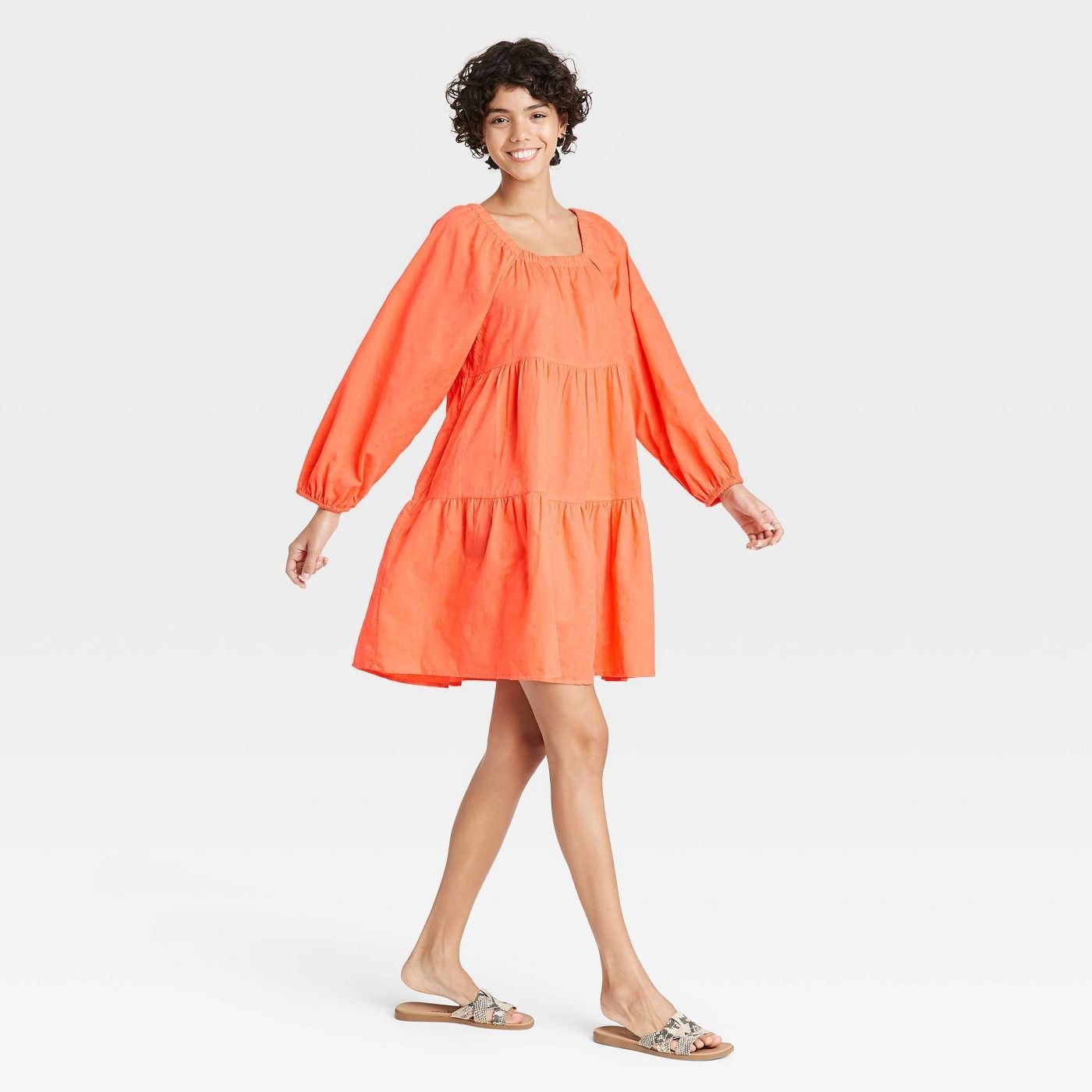 Model wearing  long sleeve orange dress