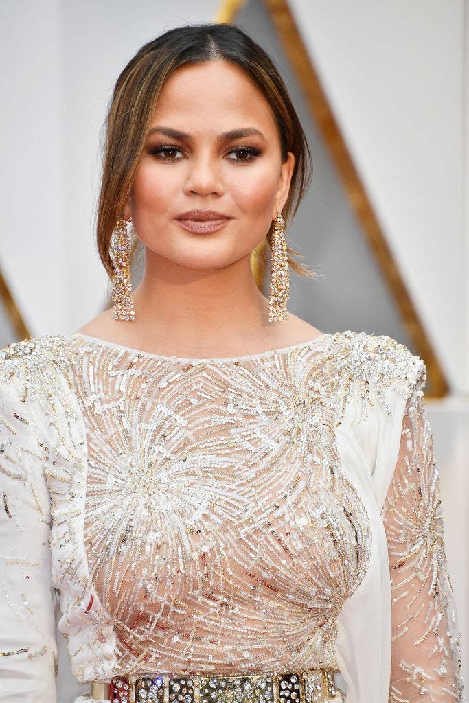 Chrissy wearing a sequined gown and her hair up on a red carpet