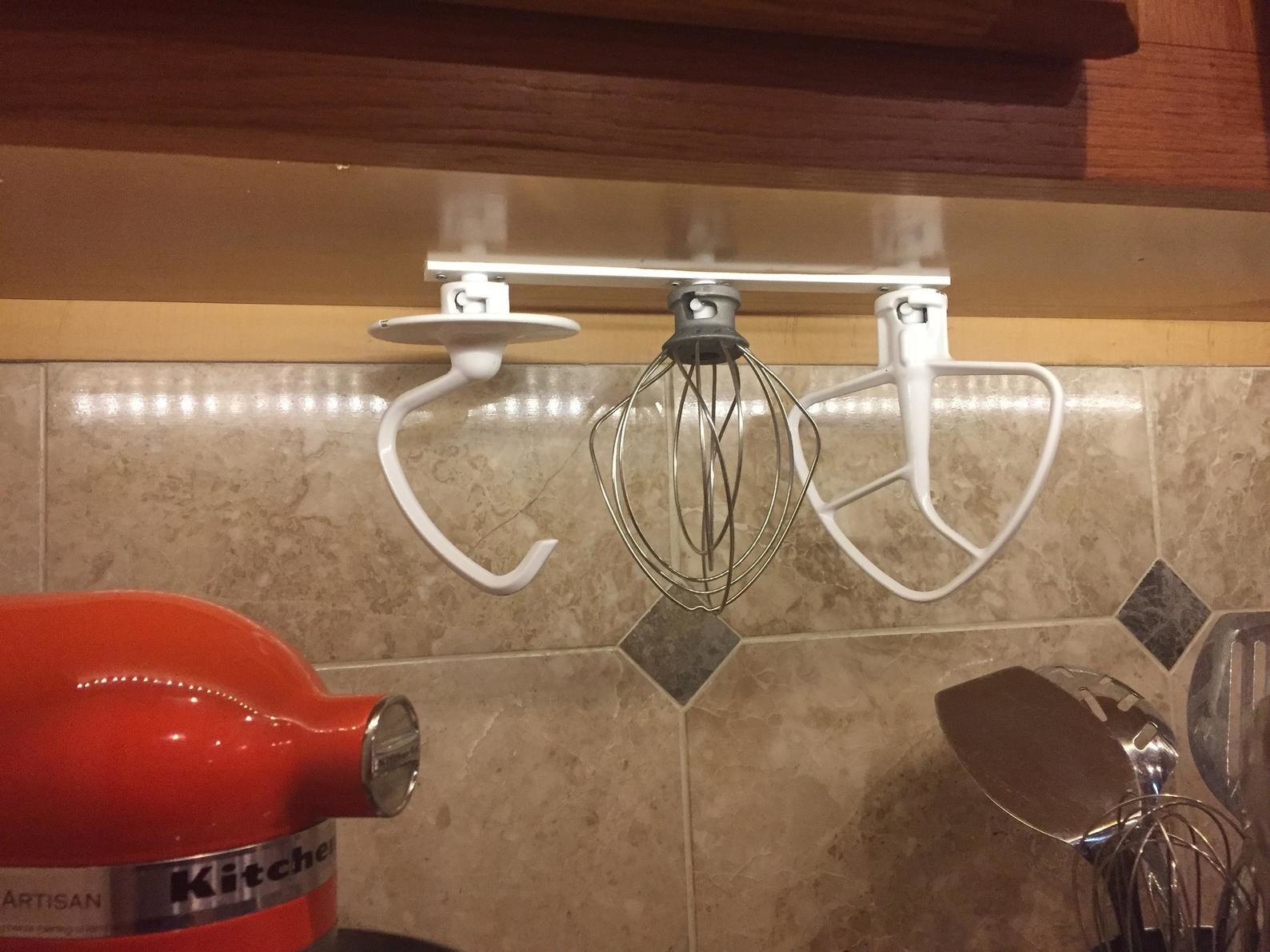 The attachments and organizer hanging from a cabinet