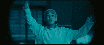 Yoo Ah-in smiles and waves at someone in the distance