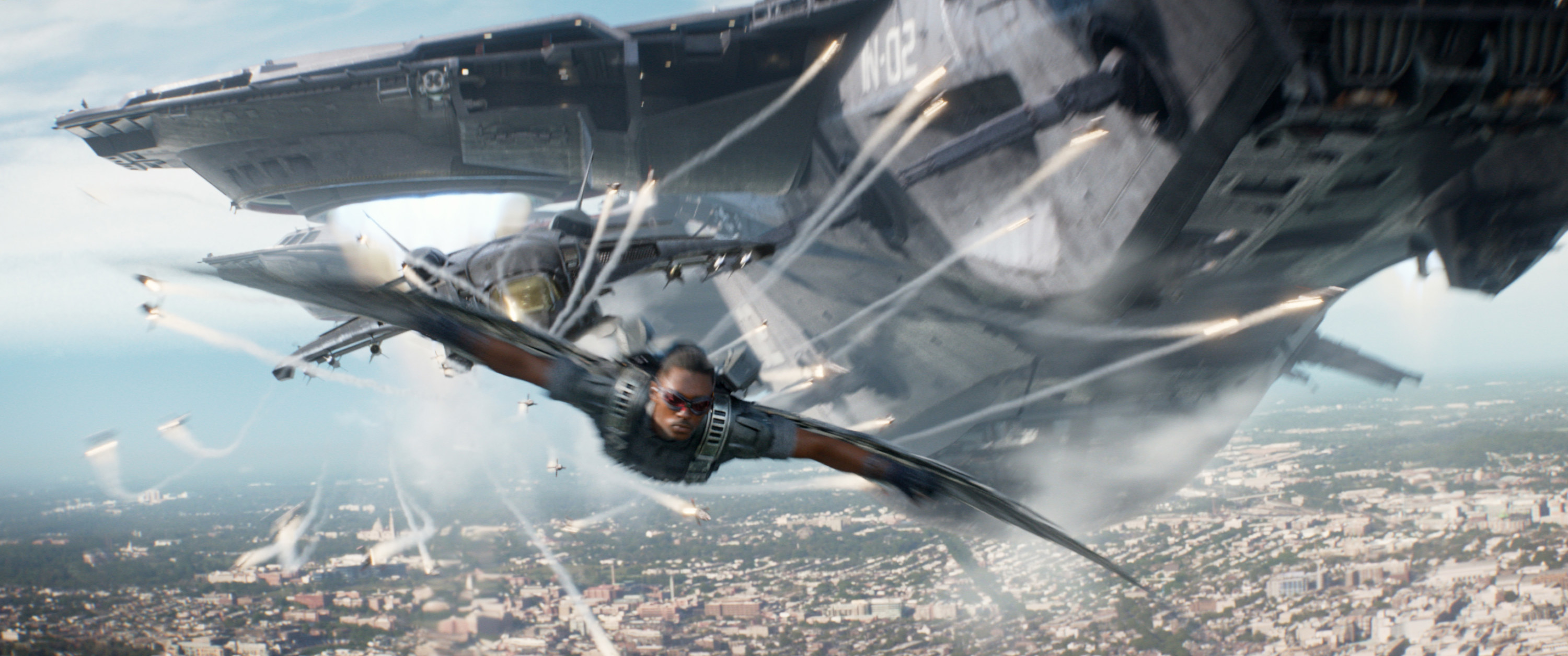 Mackie flies through the air underneath a plane as The Falcon in Captain America: The Winter Soldier