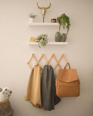 A reviewer's photo of the rack holding scarves and a backpack