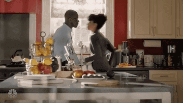 Gif of Beth kissing Randall in their kitchen