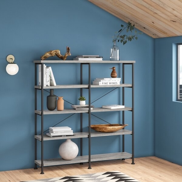 The tall bookcase with steel frame and gray wooden shelving 