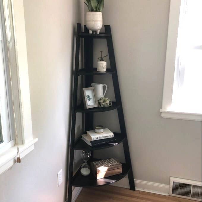 black corner bookcase with books and decorative items on it