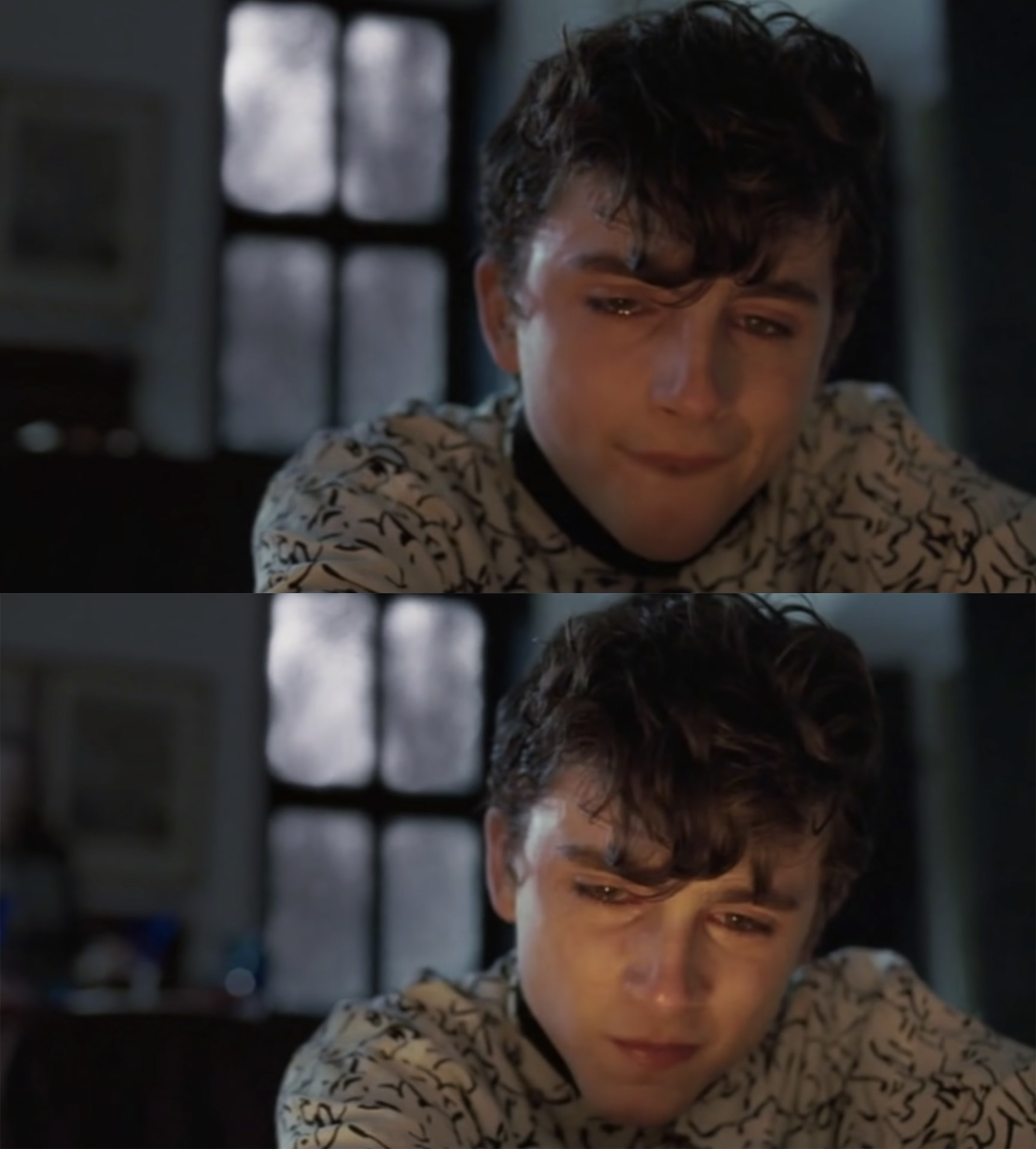 Elio sitting in front of a fireplace and silently crying. 