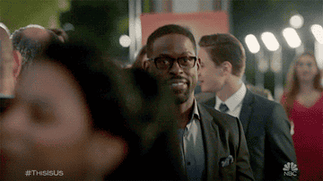 Gif of a smiling Randall walking up behind Beth to kiss her