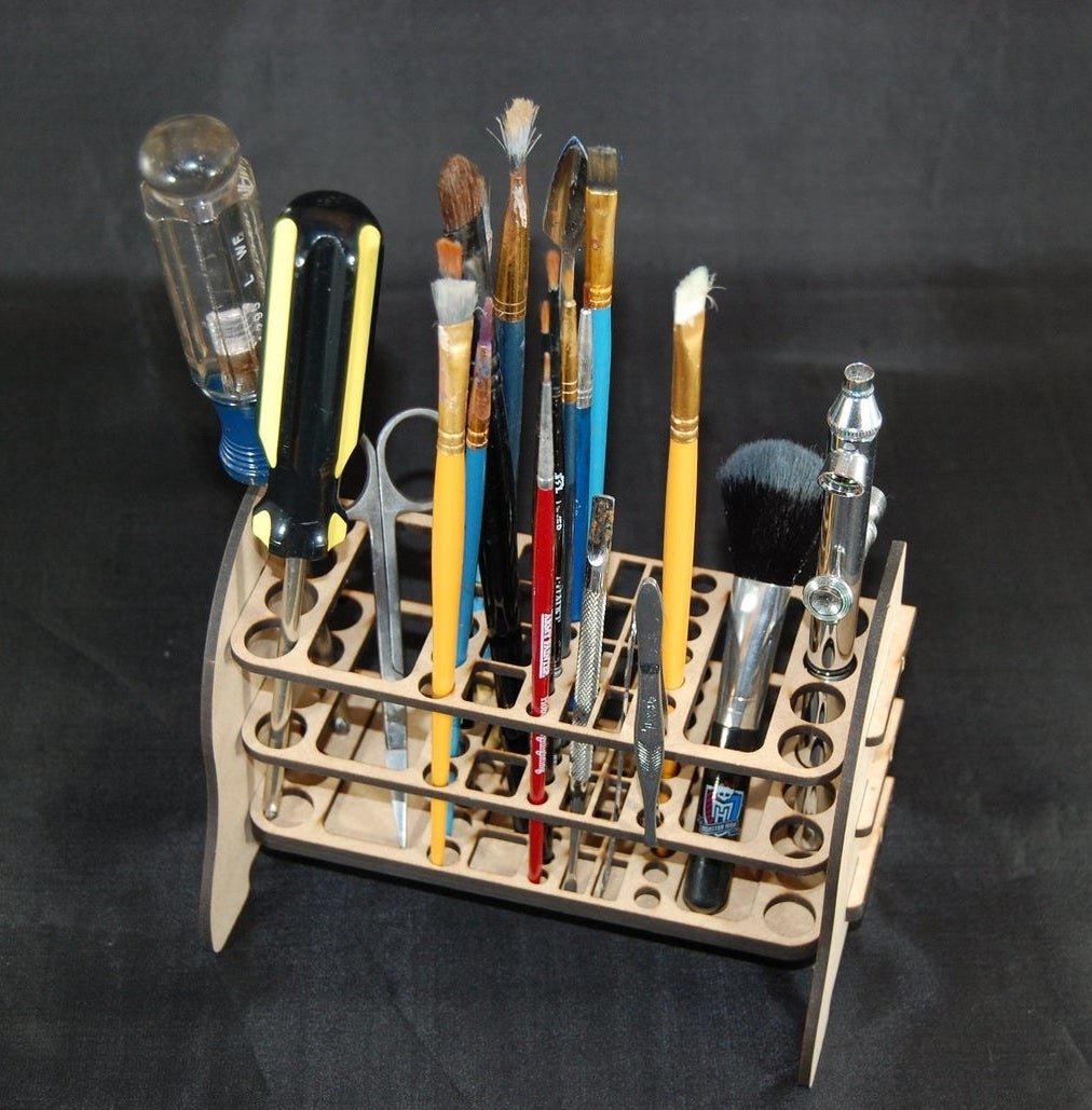 The rack holding various tools, brushes, and tweezers