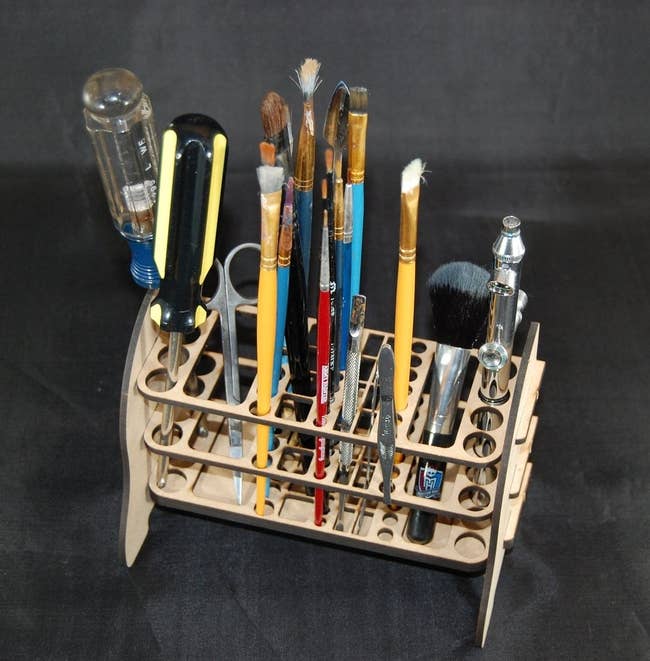 The rack holding various tools, brushes, and tweezers