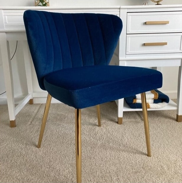 blue accent chair with gold legs and a tufted back