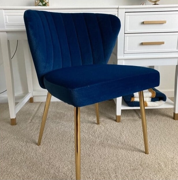 blue accent chair with gold legs and a tufted back