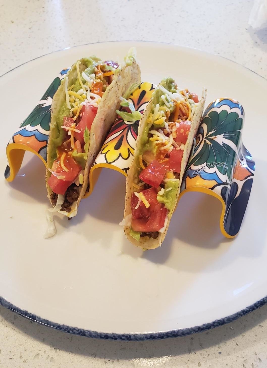 Two tacos in the multi-colored decorative taco holder