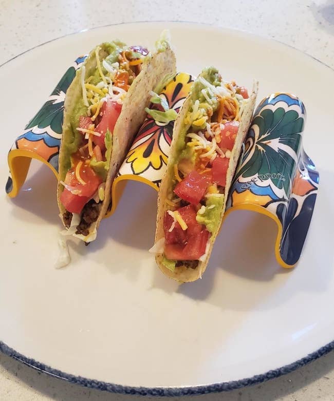 Two tacos in the multi-colored decorative taco holder