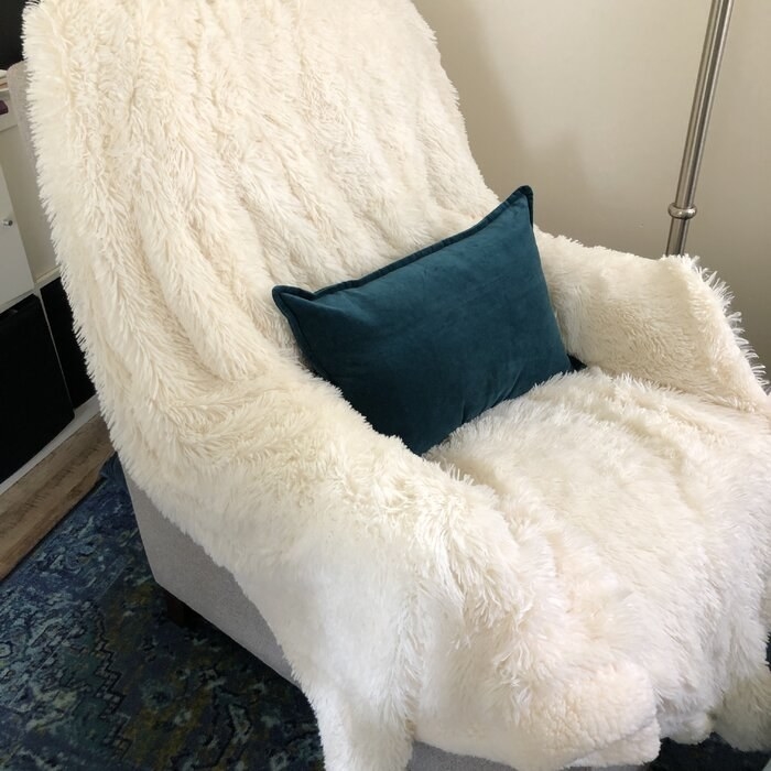 white fluffy blanket draped over a chair