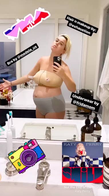 Katy taking a picture of herself in a bathroom mirror wearing a breast pumping bra and a caption saying her hair and makeup were done by exhaustion