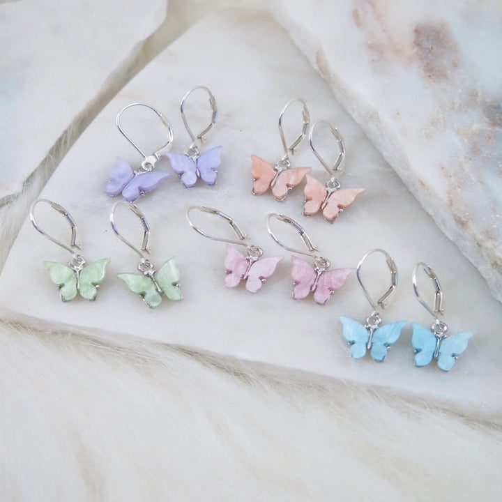 pastel mini butterfly dangling earrings on a marble table