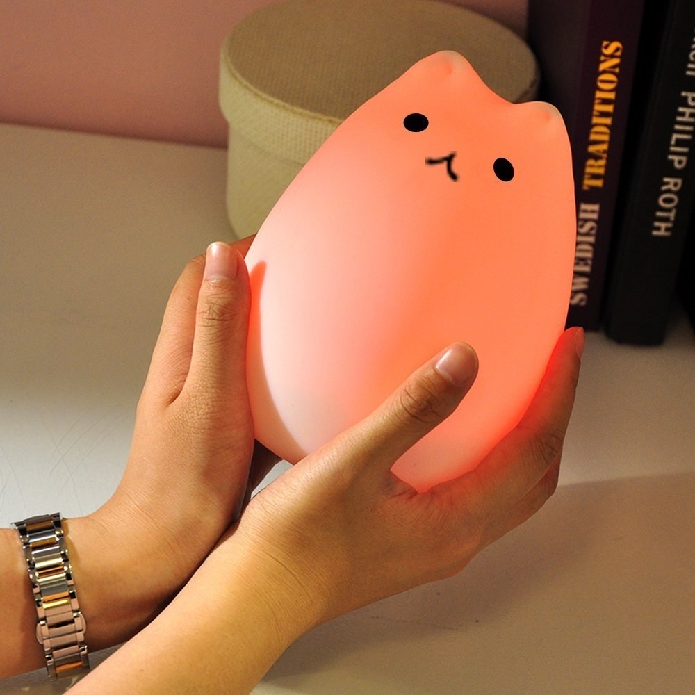A hand holding a cat lamp 