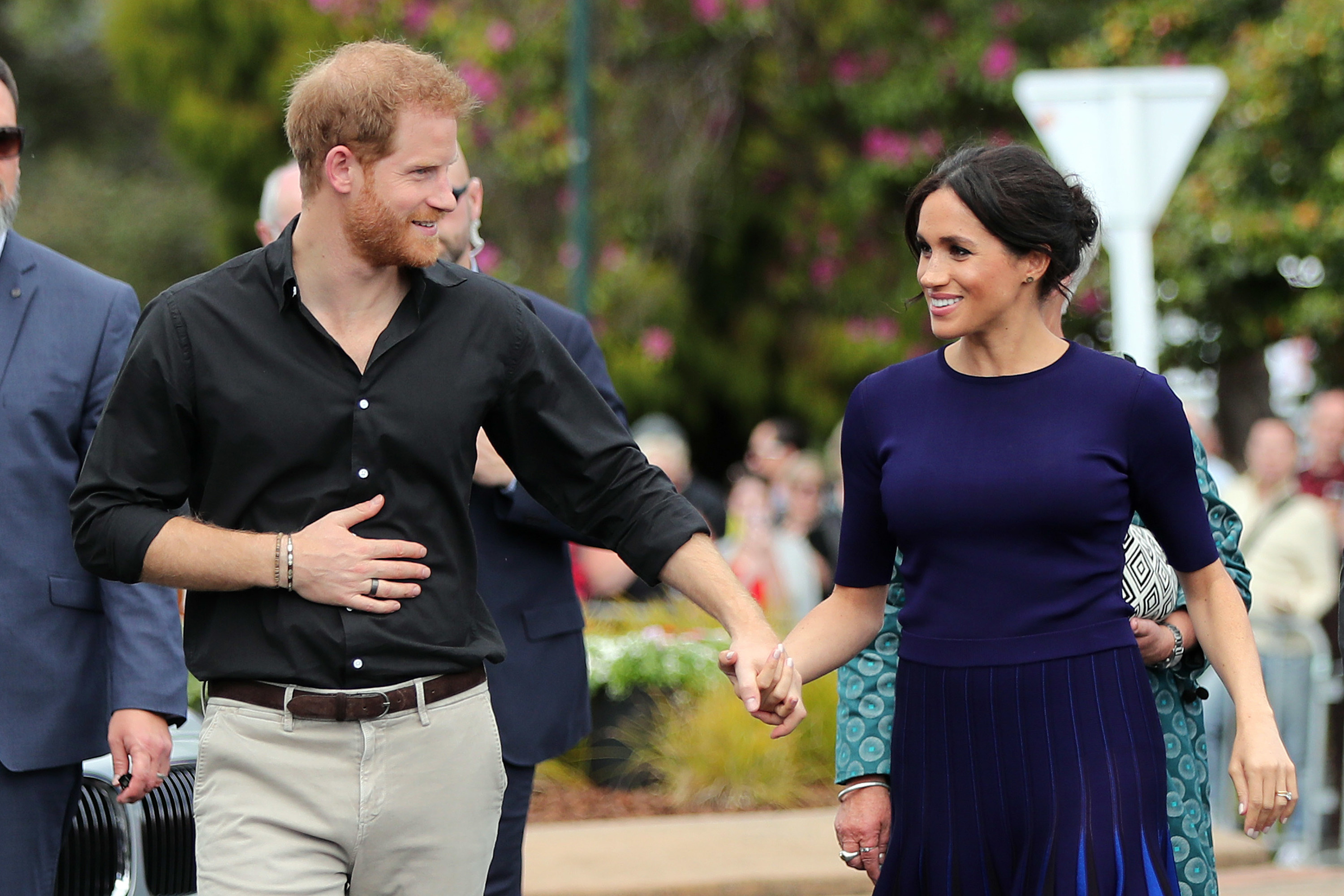 Harry and Meghan hold hands while on a walk