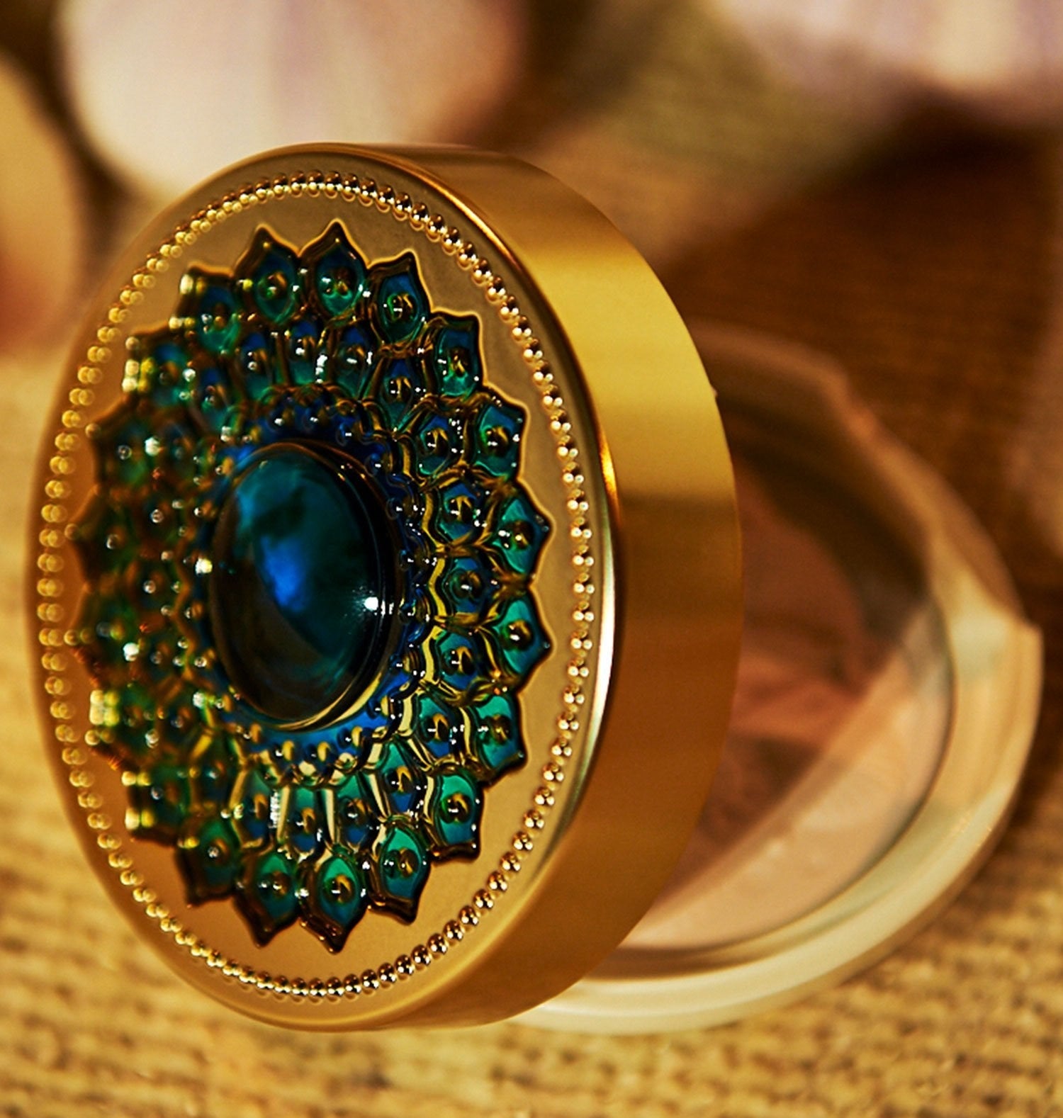 the gold case with a blue jewel in the center