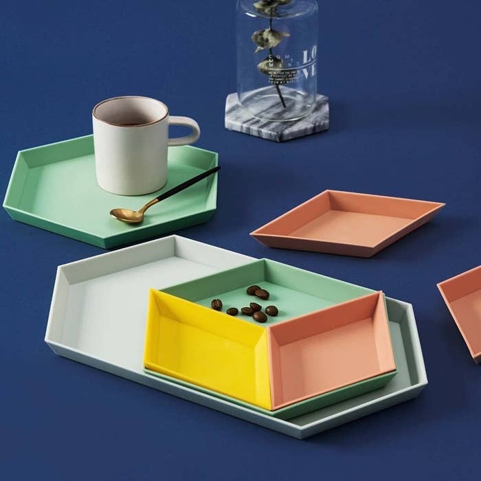 The pastel colored trays stacked and holding a mug of coffee