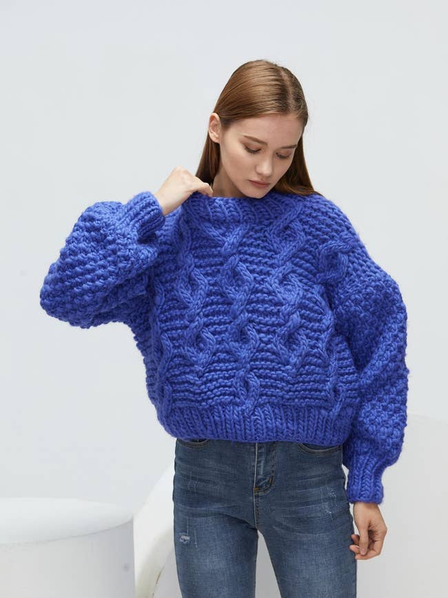 A model wearing the sweater in blue
