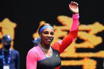 Serena Williams raises her arm in the air. 