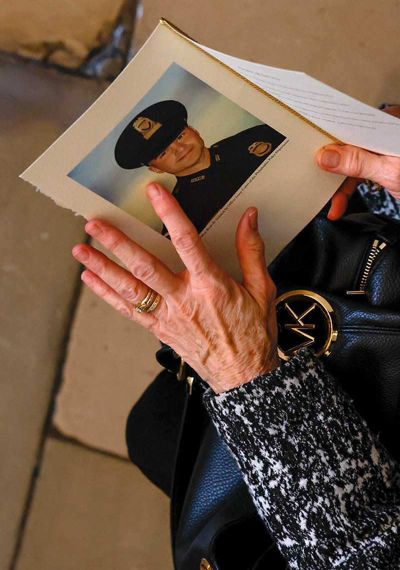 A top-down view of a person&#x27;s hands holding and touching a ceremony program