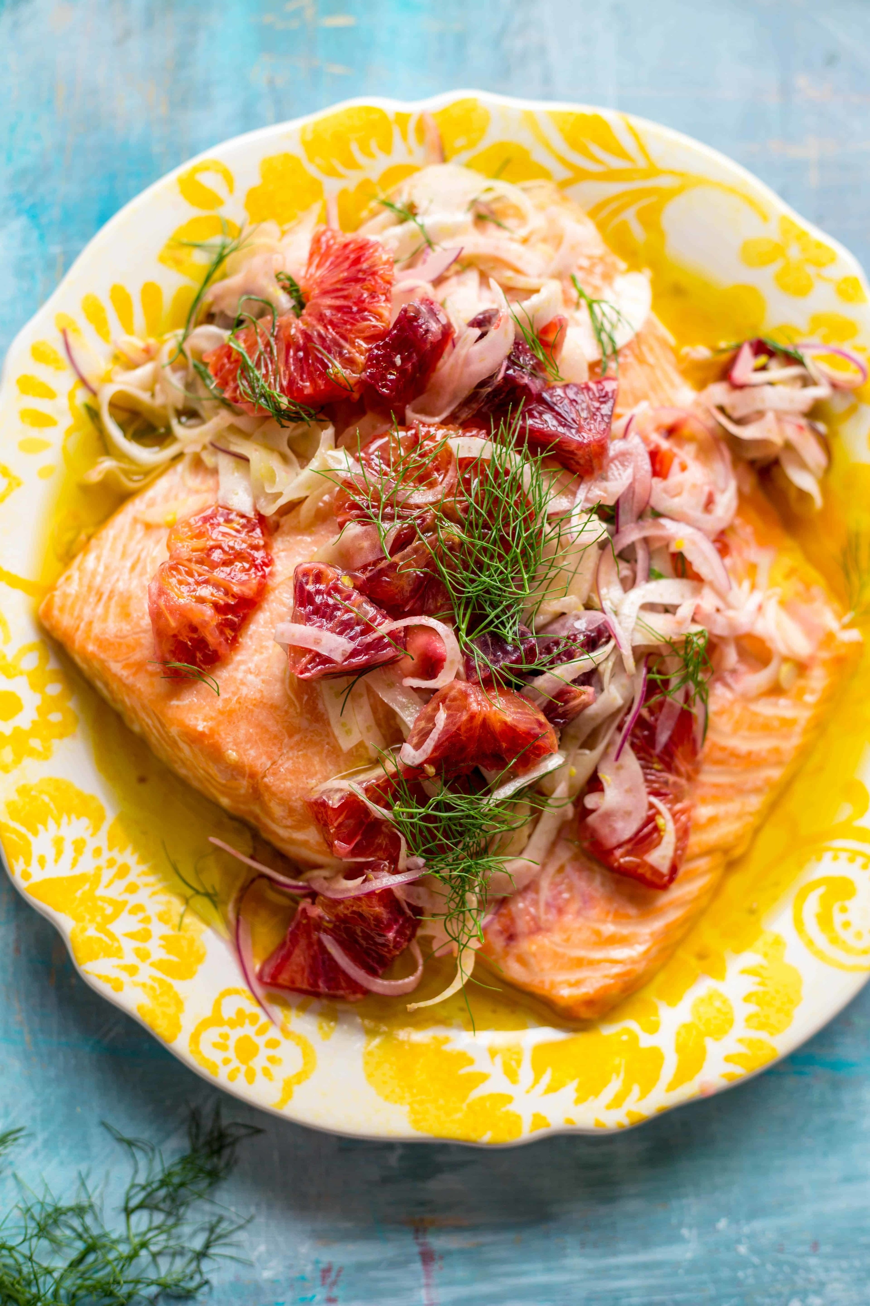 A plate of slow roasted salmon with blood orange and fennel fronds.