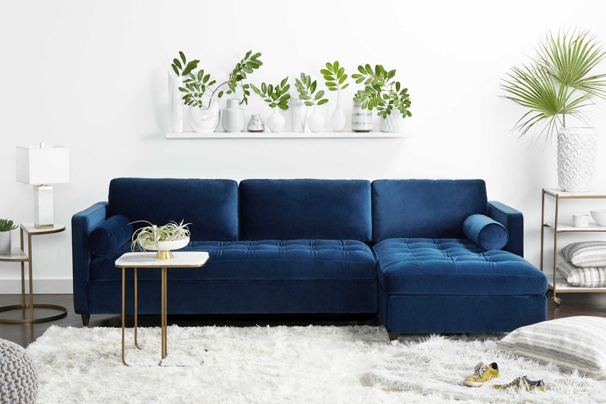 a blue velvet sofa with a chaise