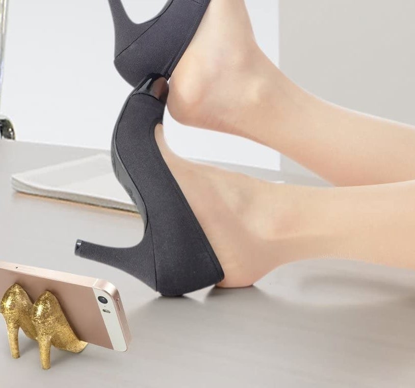 two small sparkly gold heels holding up a phone