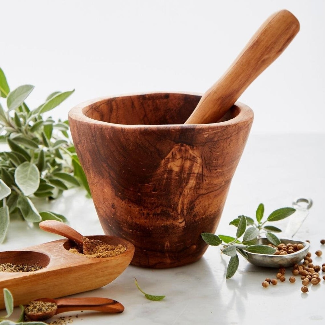 Tall wooden bowl with rounded stamping spoon 