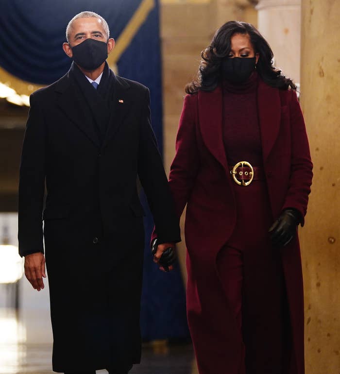Former US President Barack Obama and Michelle Obama, wearing a matching turtleneck, pants, belt, and long winter coat, arrive for President-elect Joe Biden's inauguration