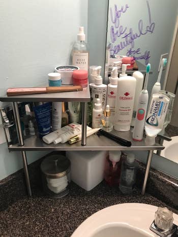 A reviewer using the shelf to hold toiletries like toothpaste, lotion, and skincare