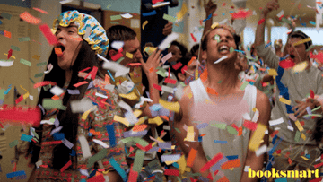 A gif from the movie Booksmart of students celebrating in a school hallway while confetti falls from the ceiling